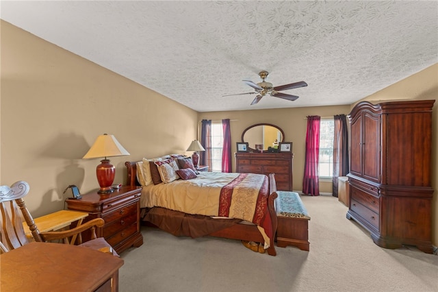 bedroom with light carpet, a textured ceiling, and ceiling fan