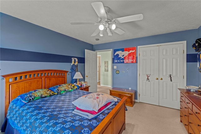 bedroom featuring light carpet, a textured ceiling, a closet, and ceiling fan