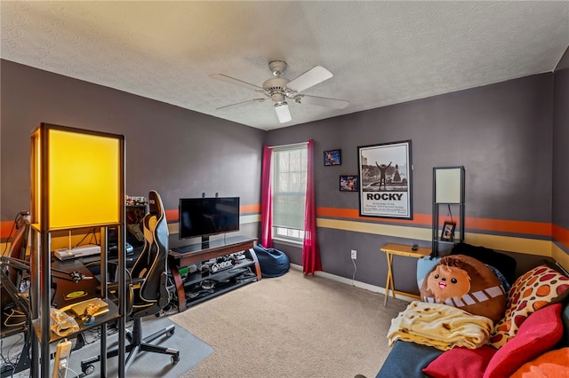 carpeted home office featuring a textured ceiling and ceiling fan