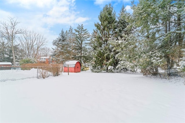 yard layered in snow featuring a storage shed