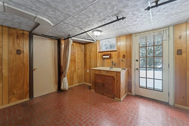 interior space featuring indoor bar, wood walls, and a healthy amount of sunlight