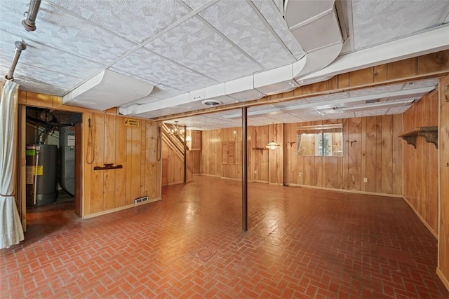 basement with wooden walls and water heater