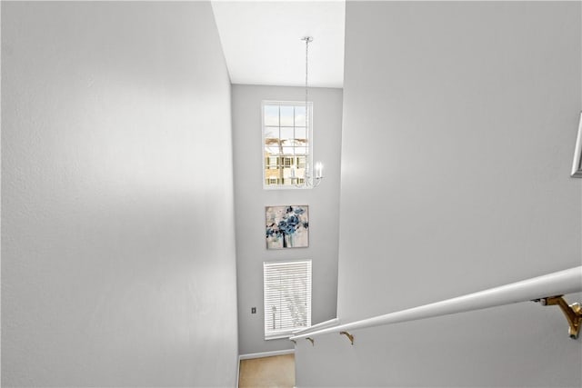 staircase with a chandelier