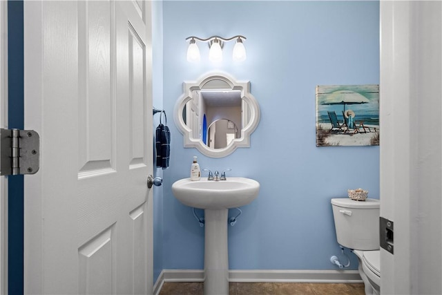 bathroom with sink, toilet, and tile patterned flooring