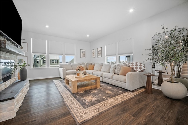 living room featuring a wealth of natural light, dark hardwood / wood-style flooring, and a fireplace