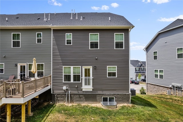 rear view of house featuring a deck, central air condition unit, and a yard