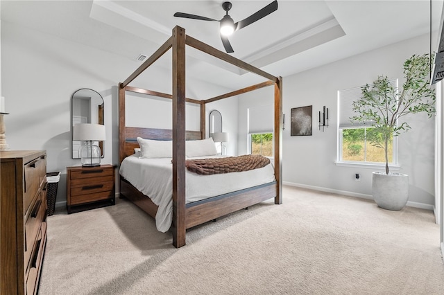 carpeted bedroom featuring ceiling fan and a tray ceiling