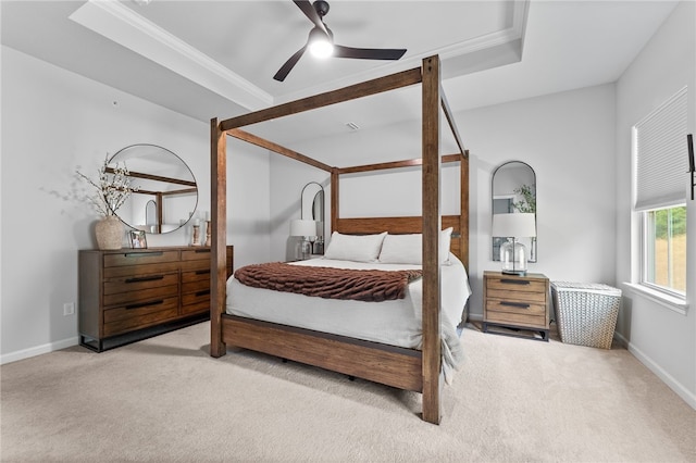 carpeted bedroom featuring ceiling fan, crown molding, and a tray ceiling