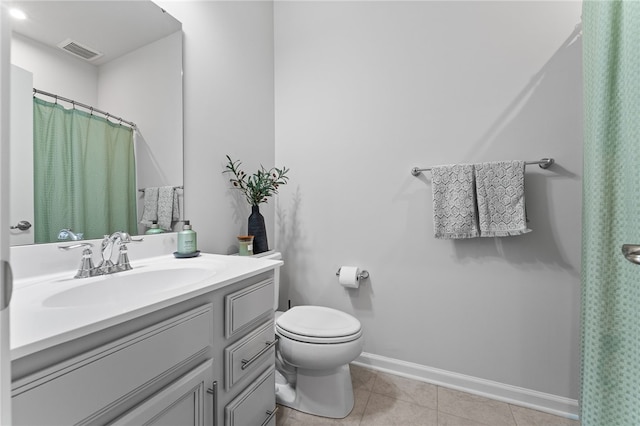 bathroom featuring toilet, vanity, and tile patterned flooring