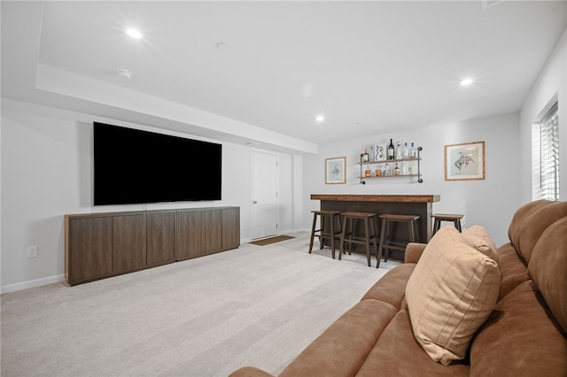 living room with bar area and light colored carpet