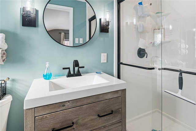 bathroom featuring vanity, toilet, and a shower with door