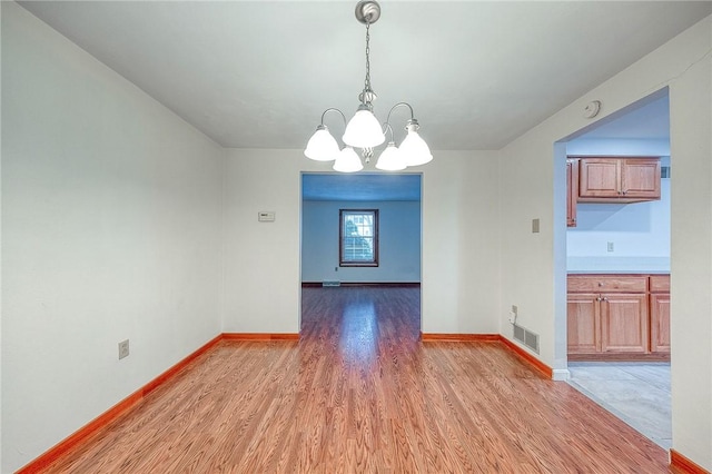 unfurnished dining area featuring hardwood / wood-style floors and a notable chandelier