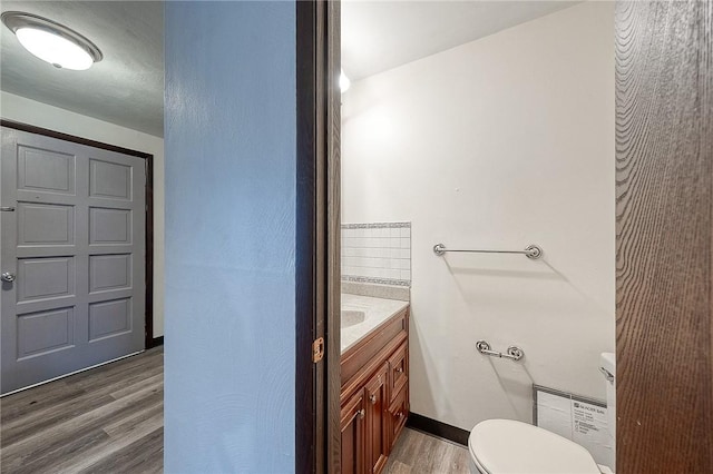 bathroom featuring vanity, toilet, and hardwood / wood-style floors