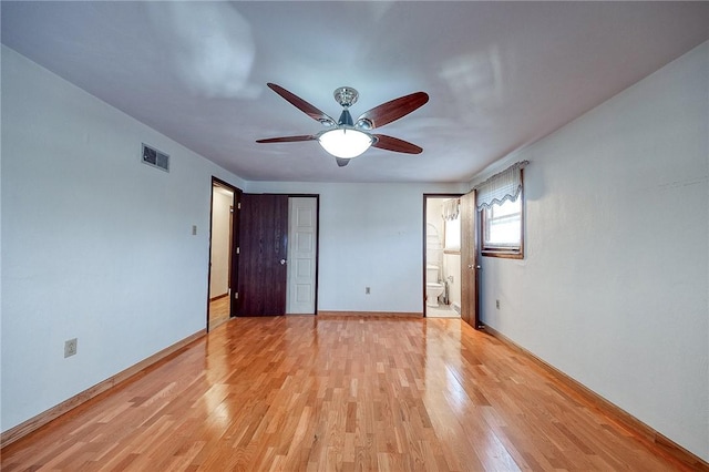 unfurnished bedroom with light wood-type flooring, a closet, ensuite bath, and ceiling fan