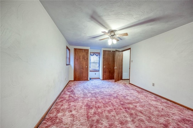 unfurnished bedroom featuring ceiling fan, a textured ceiling, and light carpet