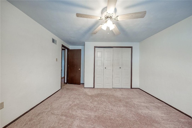 unfurnished bedroom featuring a closet, ceiling fan, and light colored carpet