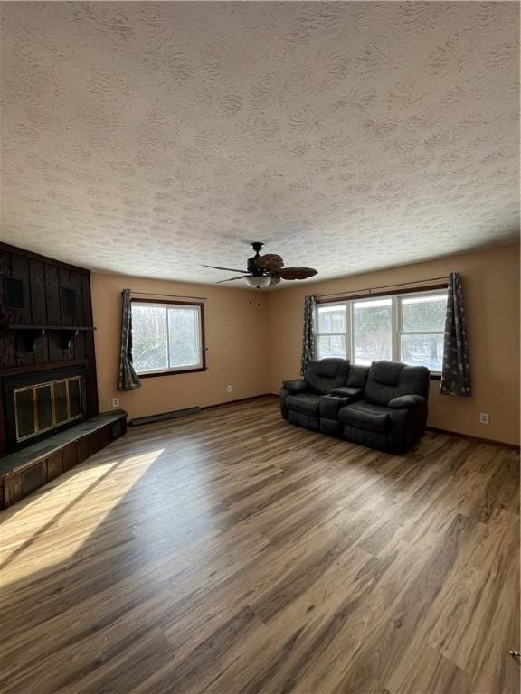 unfurnished living room with hardwood / wood-style flooring, plenty of natural light, and a textured ceiling