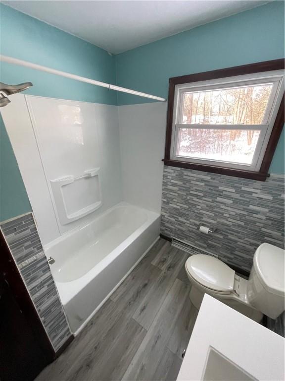 bathroom featuring toilet, tub / shower combination, and hardwood / wood-style floors