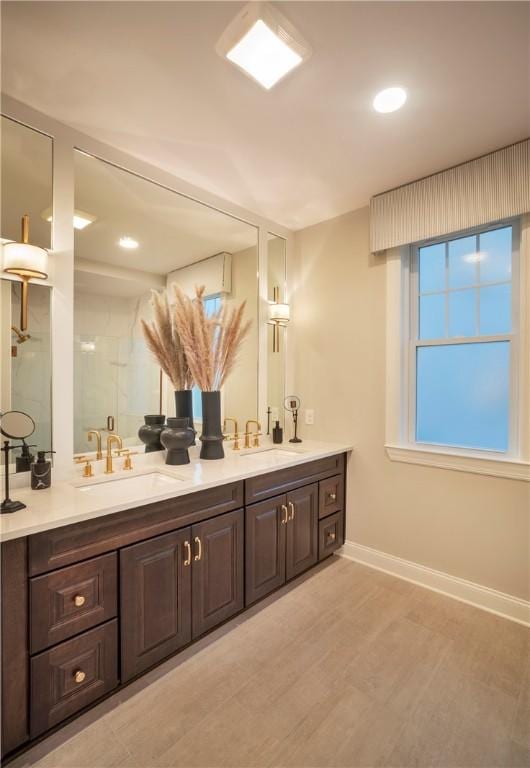 bathroom featuring hardwood / wood-style flooring, walk in shower, and vanity