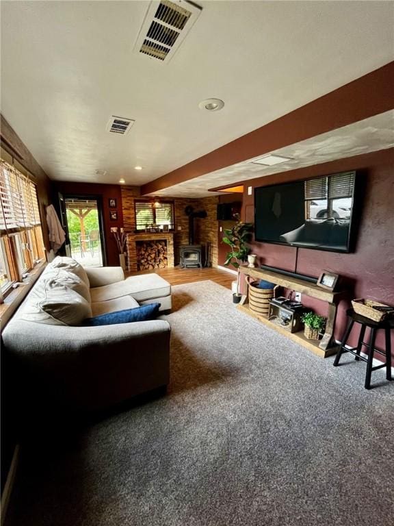 living room featuring a wood stove and carpet flooring