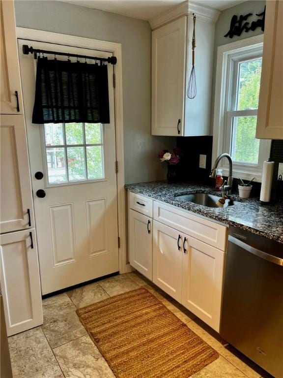 kitchen with dishwasher, white cabinetry, light tile patterned floors, sink, and dark stone countertops