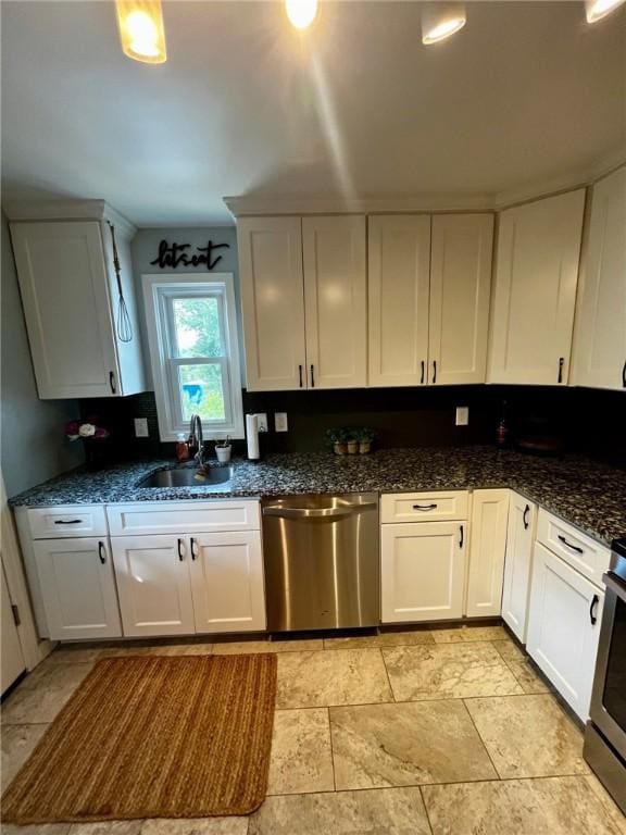 kitchen featuring sink, white cabinetry, stainless steel appliances, and dark stone counters