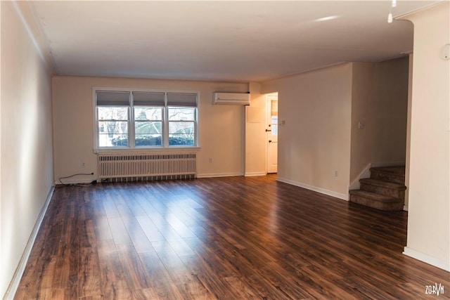 spare room featuring radiator heating unit, a wall mounted AC, ornamental molding, and dark hardwood / wood-style flooring