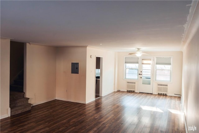 unfurnished living room with ceiling fan, radiator heating unit, electric panel, and wood-type flooring