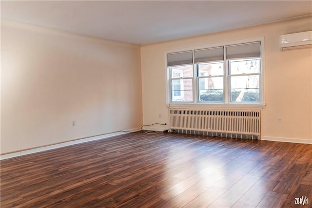 spare room featuring a wall mounted AC, radiator, and dark hardwood / wood-style flooring