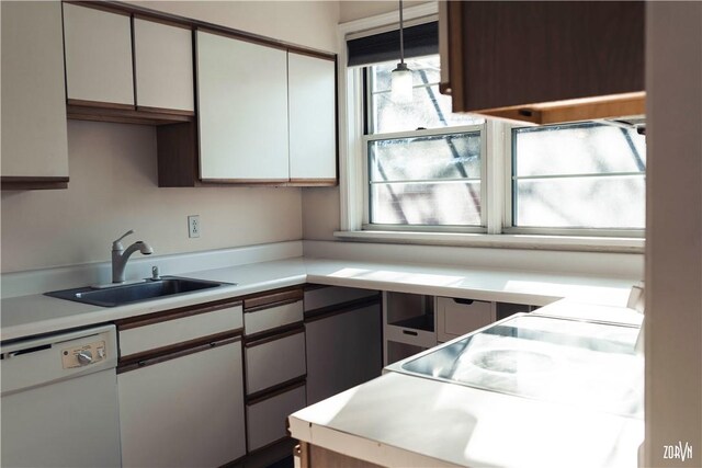 kitchen featuring sink, hanging light fixtures, white cabinets, and dishwasher