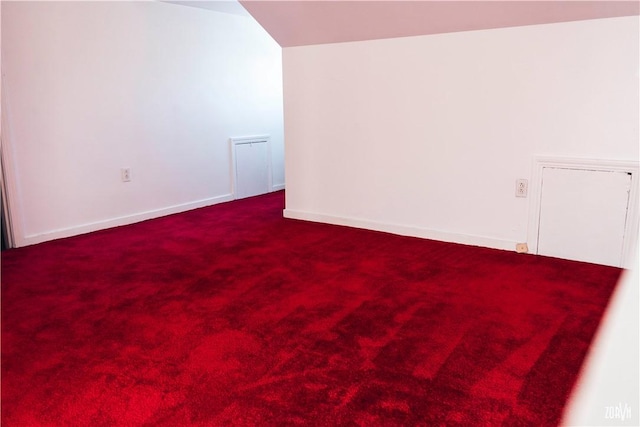 carpeted empty room with lofted ceiling