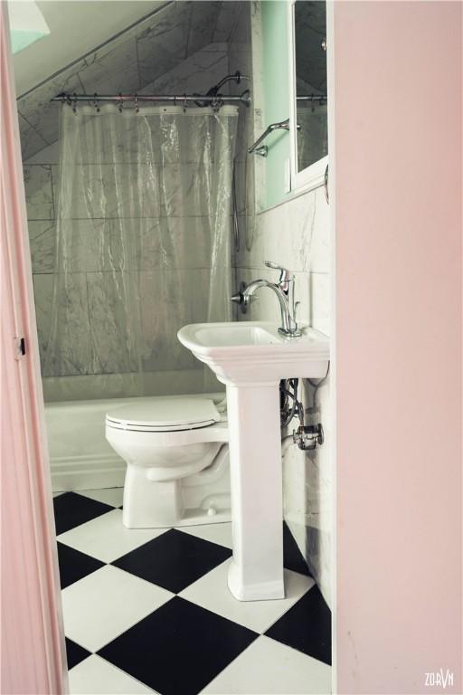 bathroom featuring curtained shower and toilet