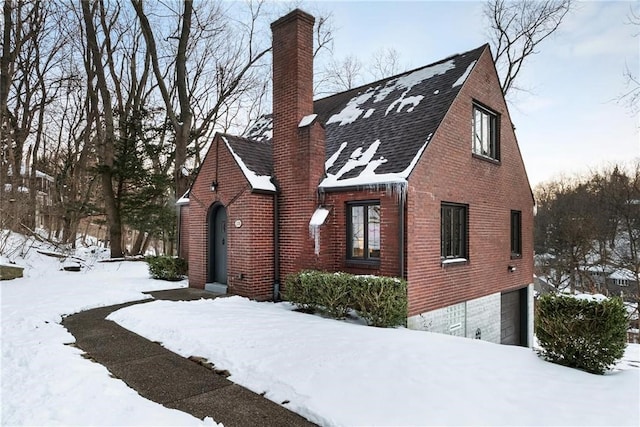 view of snowy exterior featuring a garage