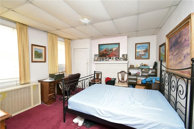 bedroom with multiple windows, carpet, radiator heating unit, and a drop ceiling