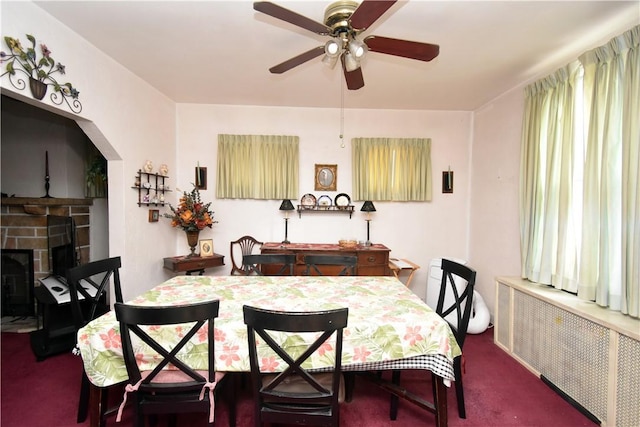 carpeted dining space featuring radiator and ceiling fan