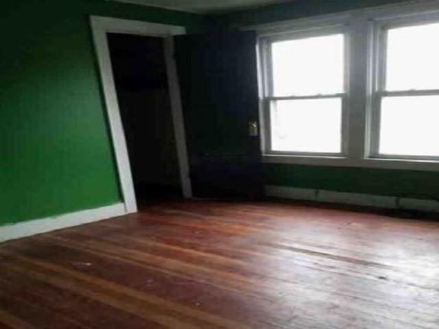 unfurnished room with wood-type flooring