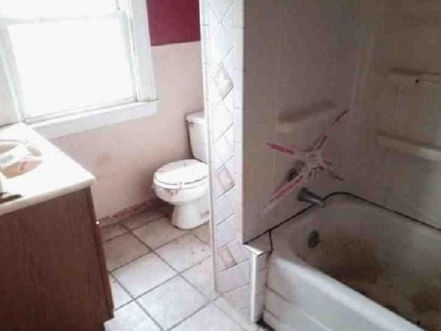 full bathroom with  shower combination, toilet, tile patterned floors, and vanity