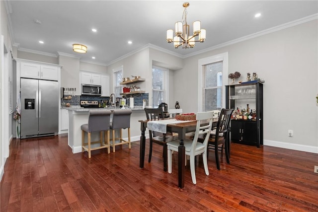 dining area featuring dark wood-type flooring, ornamental molding, and an inviting chandelier