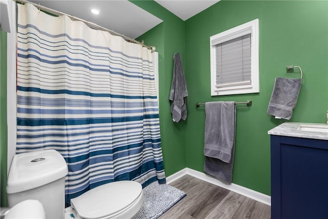 bathroom featuring hardwood / wood-style floors, toilet, a shower with shower curtain, and vanity