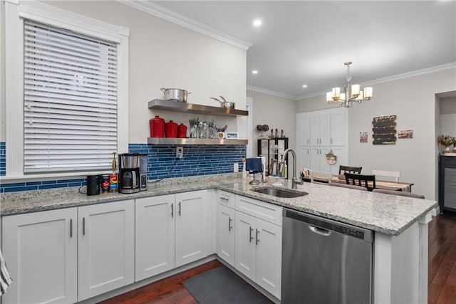 kitchen featuring kitchen peninsula, stainless steel dishwasher, pendant lighting, sink, and white cabinets