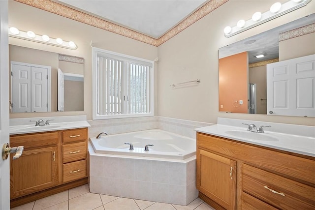 bathroom featuring tiled tub, tile patterned floors, and vanity