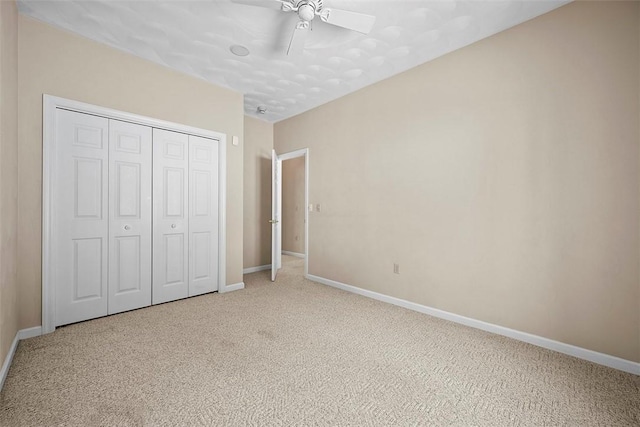 unfurnished bedroom featuring carpet flooring, a closet, and ceiling fan