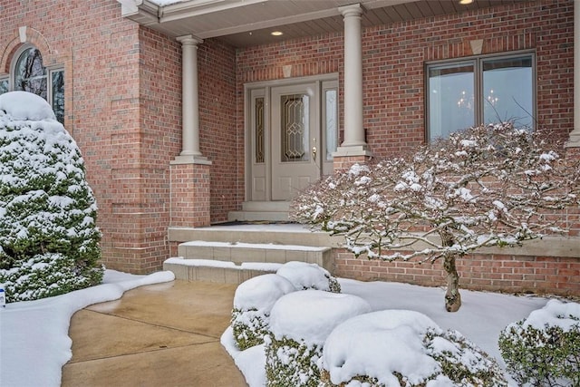 snow covered property entrance featuring a porch