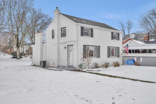 snow covered rear of property featuring central air condition unit