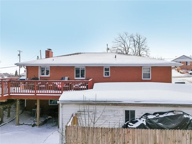 snow covered property with a deck and central AC