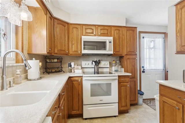 kitchen with sink, white appliances, and decorative backsplash