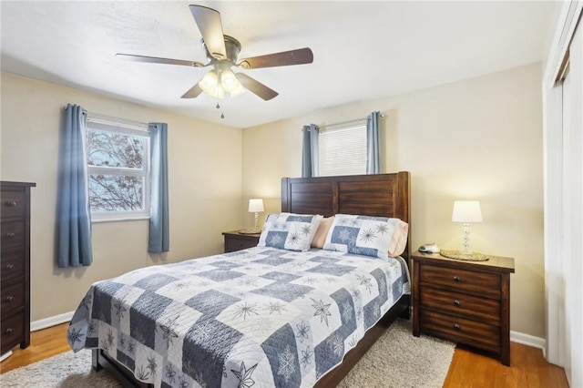 bedroom featuring ceiling fan, light hardwood / wood-style floors, and a closet