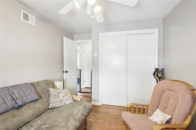 living room with light wood-type flooring and ceiling fan