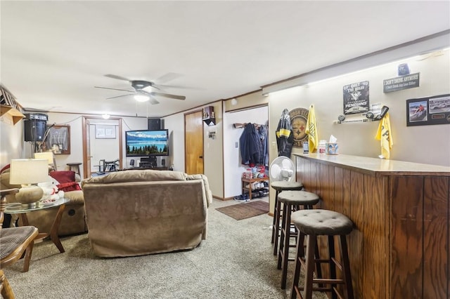 living room with carpet flooring, bar area, and ceiling fan