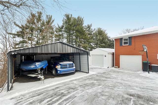 snow covered garage with a carport